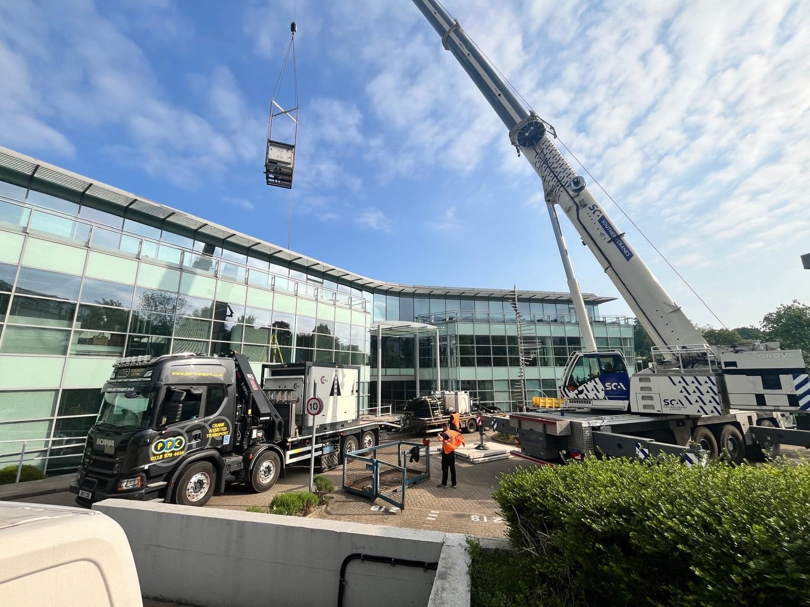 Office cooling install of 300kw chiller hire, being craned in over a large building